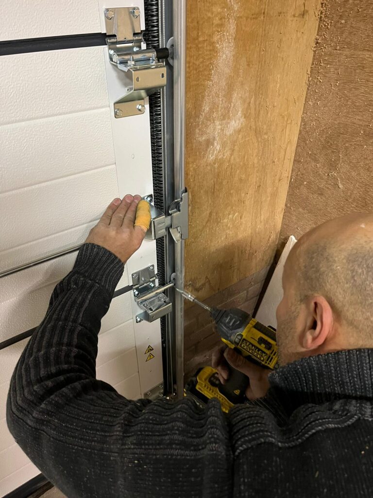 Monteur monteert sectionale garagedeur met elektrische aandrijving