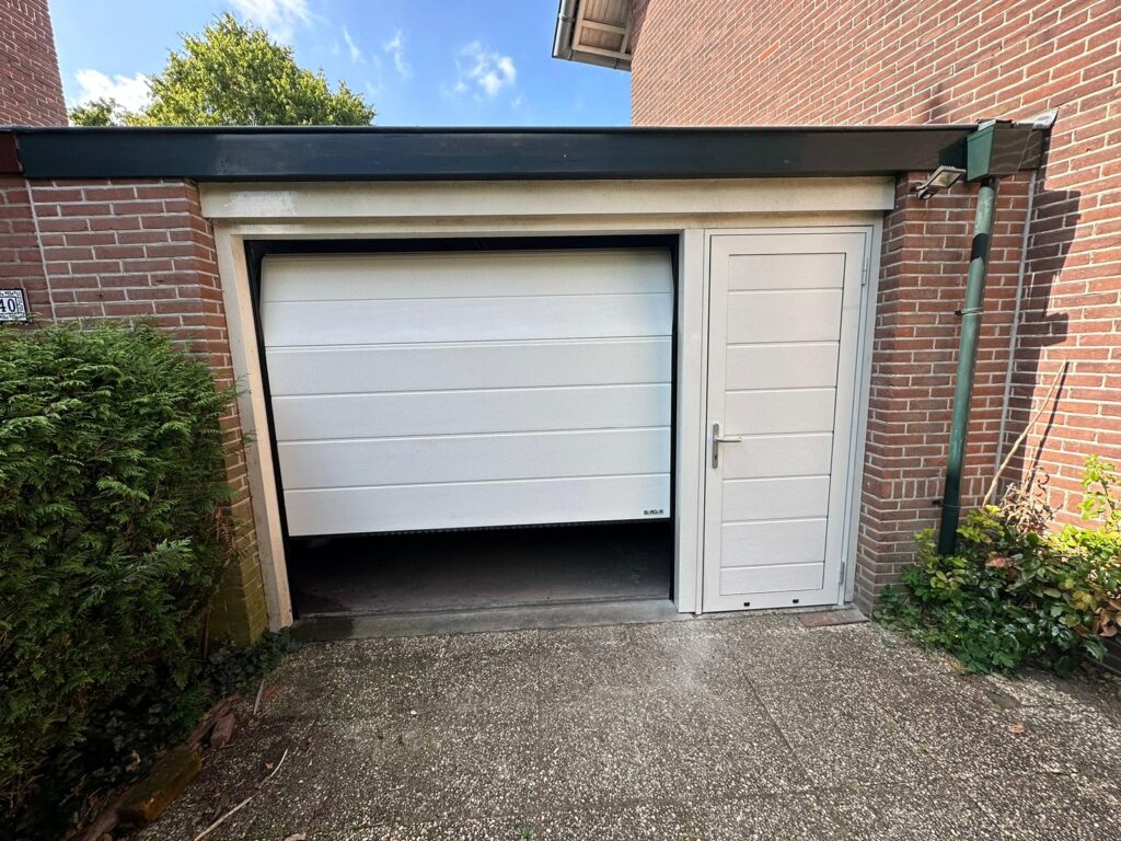 Sectionale garagedeuren Woodgrain Ligna in RAL 9010 zuiverwit met enkele loopdeur ernaast